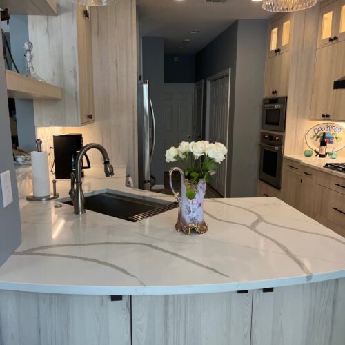 Modern Kitchen Island with Curved Design, Quartz Countertop & Pendant Lights