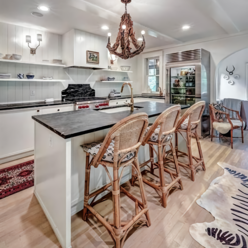 Coastal Kitchen with White Cabinets, Soapstone Island & Wicker Bar Stools