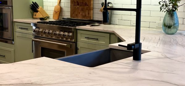 Modern Kitchen Close-up: Black Faucet, Quartzite Counter & Sage Green Cabinets