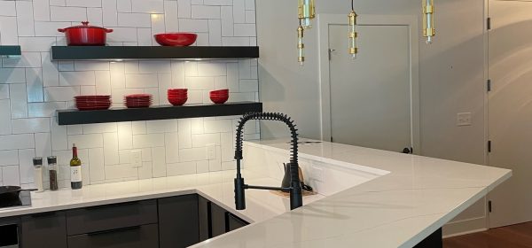 Modern Kitchen Corner with Black & White Accents, Red Cookware & Gold Pendants